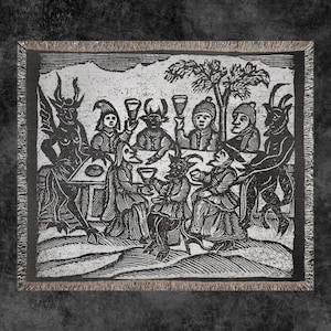 May include: Black and white woven tapestry featuring a group of figures with horns and tails gathered around a table, drinking from goblets. The figures are dressed in medieval clothing and appear to be celebrating.