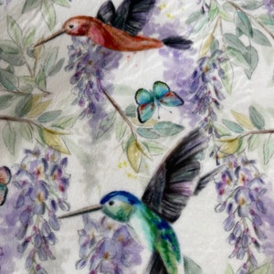 May include: A white background with a watercolour design of purple wisteria flowers and two hummingbirds. One hummingbird is red and black, the other is green and blue.