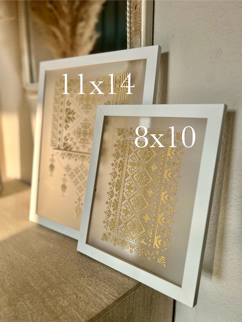 K&ouml;nnte beinhalten: Zwei wei&szlig;e Bilderrahmen mit goldenen geometrischen Mustern im Inneren. Der gr&ouml;&szlig;ere Rahmen ist mit "11x14" beschriftet und der kleinere Rahmen mit "8x10".