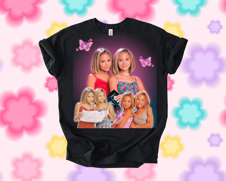 Pu&ograve; includere: T-shirt nero con una grafica di due donne e farfalle. La grafica include pi&ugrave; immagini delle donne in diversi outfit. Lo sfondo &egrave; una sfumatura di viola e rosa.