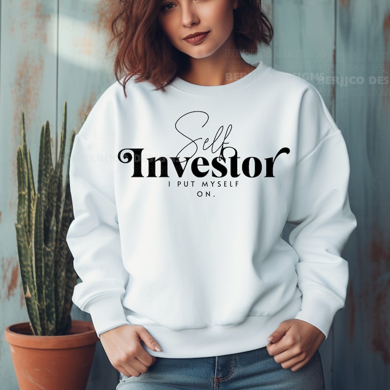 May include: White sweatshirt with black text that reads "Self Investor I PUT MYSELF ON."