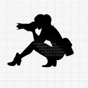 May include: Silhouette of a person crouching and holding a camera. The person is wearing a shirt and pants. The person is facing to the left.
