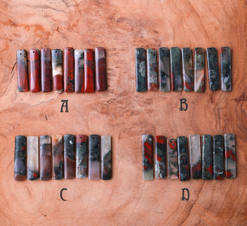 May include: Four sets of rectangular gemstone pendants, each with a hole for stringing. The pendants are in shades of red, green, gray, and white. The letter A, B, C, and D are below each set of pendants.