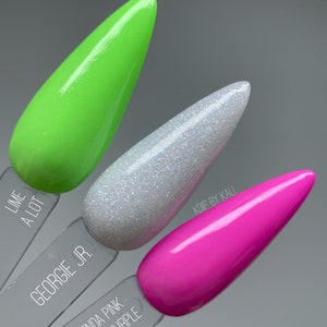 May include: Three nail polish bottles with different colors and names. The first bottle is green and labeled "Lime A Lot". The second bottle is white with glitter and labeled "Georgie Jr.". The third bottle is pink and labeled "Kinda Pink Kinda Purple".