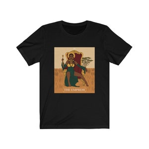 May include: Black t-shirt with a graphic of the Empress tarot card featuring a Black woman in a green dress sitting on a throne. The card is labeled "III THE EMPRESS".