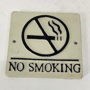 May include: White cast iron sign with a black no smoking symbol and the text "NO SMOKING".
