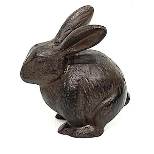May include: A dark brown rabbit figurine with long ears and a textured surface. The rabbit is in a seated position, with its ears perked up. This decorative item is suitable for home decor.