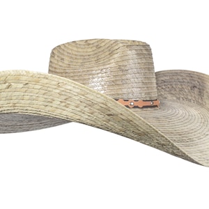 K&ouml;nnte beinhalten: Ein breitkrempiger Strohhut im Cowboy-Stil mit einem braunen Lederband und dekorativen N&auml;hten. Der Hut ist aus nat&uuml;rlichem gewebtem Stroh gefertigt und hat einen leicht abgenutzten Look.