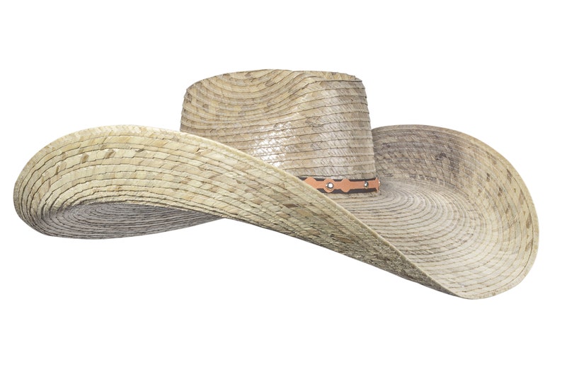 K&ouml;nnte beinhalten: Ein breitkrempiger Strohhut im Cowboy-Stil mit einem braunen Lederband und dekorativen N&auml;hten. Der Hut ist aus nat&uuml;rlichem gewebtem Stroh gefertigt und hat einen leicht abgenutzten Look.