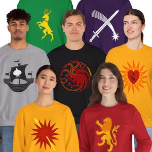 May include: Six different crewneck sweatshirts featuring various house sigils from the popular TV show Game of Thrones. The sigils are embroidered on the front of each sweatshirt. The sweatshirts are available in a variety of colors, including gray, black, green, purple, yellow, and red.