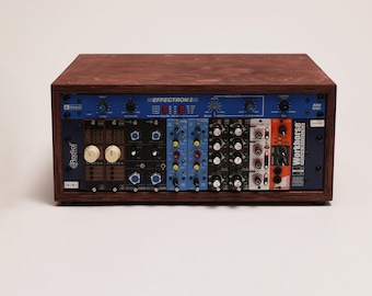 May include: A rectangular wooden rack housing an Effectron II digital delay unit with a blue faceplate, positioned above a series of modular audio components including Radial and Workhorse Powerhouse modules with various knobs, switches, and ports.