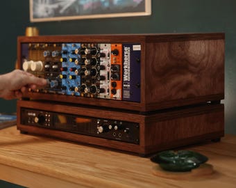 May include: A wooden rack enclosure containing multiple audio modules with knobs and switches, stacked on top of a black audio interface unit. The top unit features a blue module labeled Workhorse Powerhouse with various colorful control panels.