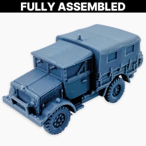 May include: A fully assembled, grey model truck with a canvas-covered rear. The truck has detailed tyres, a front cab, and the text "FULLY ASSEMBLED" in white at the top. The model is designed with intricate details.