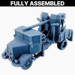 May include: A fully assembled, blue model of a military truck with a large gun mounted on the back. The model has detailed features, including wheels, a cab, and a gun barrel. The text "FULLY ASSEMBLED" is printed at the top.