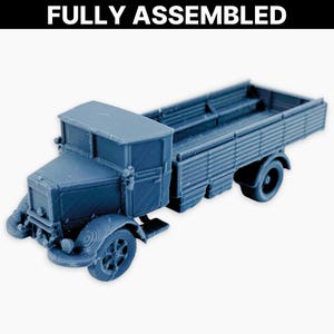 Puede incluir: Un modelo de camión azul con el texto "FULLY ASSEMBLED" en la parte superior. El camión tiene una cabina, una plataforma y ruedas detalladas. El modelo es una réplica en miniatura de un camión antiguo.