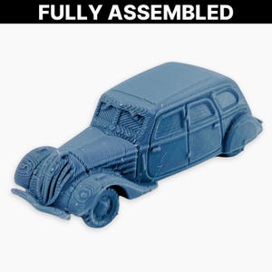 May include: A blue, fully assembled miniature car with detailed design. The car features a classic vintage style with visible lines and textures, including the text "FULLY ASSEMBLED" at the top.