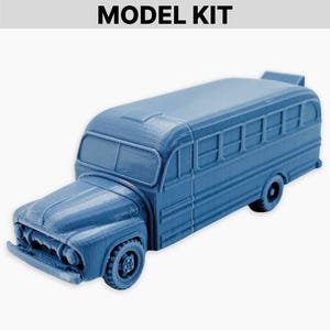 May include: A blue model kit of a vintage school bus. The bus has detailed molding, including the front grill, headlights, and side windows. The text "MODEL KIT" is at the top of the image.