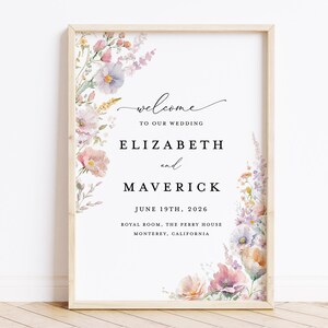 May include: A wedding announcement sign with a floral border. The sign reads "Welcome to our wedding, Elizabeth and Maverick, June 19th, 2026, Royal Room, The Perry House, Monterey, California."