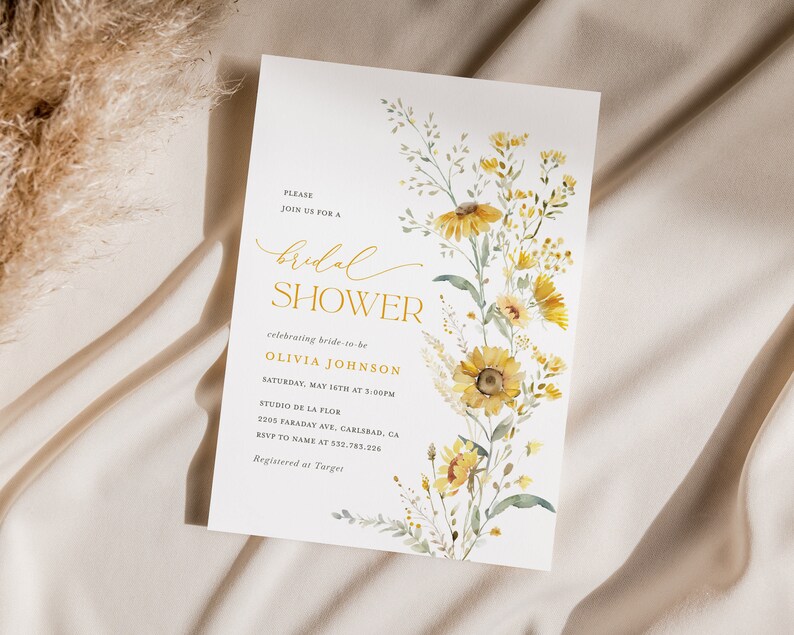 May include: A white bridal shower invitation with a watercolor illustration of yellow wildflowers. The text reads "Please join us for a bridal shower celebrating bride-to-be Olivia Johnson, Saturday, May 16th at 3:00pm, Studio de la Flor, 2005 Faraday Ave, Carlsbad, CA, RSVP to name at 552-783-296, Registered at Target."
