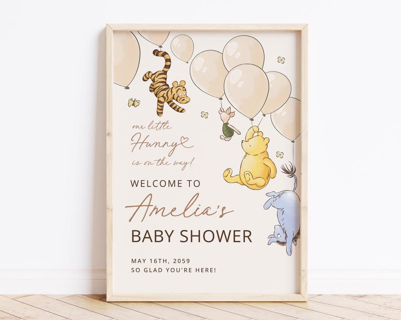 Pode incluir: Uma placa de ch&aacute; de beb&eacute; emoldurada com personagens de Winnie the Pooh e bal&otilde;es. A placa diz "Bem-vindo ao ch&aacute; de beb&eacute; de Amelia" com a data de 16 de maio de 2059. A arte inclui Tigr&atilde;o, Leit&atilde;o, Pooh e Eeyore.