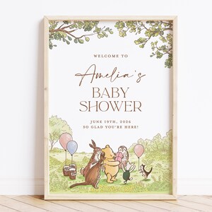 Puede incluir: Una invitaci&oacute;n a una baby shower con tem&aacute;tica de Winnie the Pooh con una ilustraci&oacute;n de acuarela de Winnie the Pooh y sus amigos. El texto dice "Bienvenido a la baby shower de Amelia 19 de junio de 2026 &iexcl;Encantados de que est&eacute;s aqu&iacute;!"