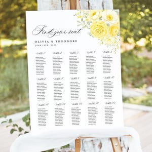 Puede incluir: Un plano de asientos de boda blanco sobre caballete, con el texto "Find your seat" y los nombres Olivia & Theodore, con fecha 19 de junio de 2053. Decorado con detalles florales amarillos.