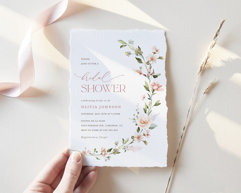 May include: A white bridal shower invitation with a floral design in shades of pink and green. The text reads "Please join us for a bridal shower celebrating bride-to-be Olivia Johnson Saturday, May 16th at 3:00PM Studio de la Flor 2205 Faraday Ave, Carlsbad, CA RSVP to name at 532-783-226 Registered at Target"