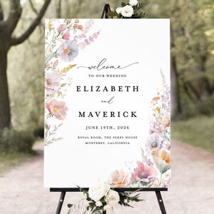 May include: A white wedding welcome sign with a floral design featuring pink, purple, and yellow flowers. The sign reads "Welcome to our wedding, Elizabeth and Maverick, June 19th, 2026, Royal Room, The Perry House, Monterey, California."