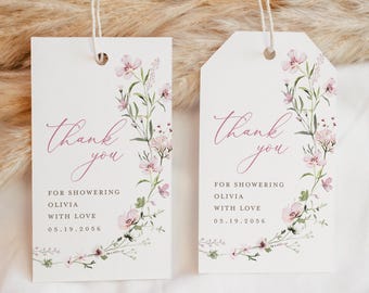 Op de afbeelding: Twee witte bedankkaartjes met roze bloemenmotieven en de tekst "dankjewel" in cursief. De tekst "Voor het geven van een babyshower voor Olivia met liefde 05.19.2056" staat onder het bloemenmotief.