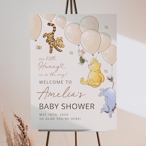 Pode incluir: Uma placa de ch&aacute; de beb&ecirc; com ilustra&ccedil;&otilde;es de personagens de Winnie the Pooh e bal&otilde;es. A placa diz "Bem-vindo ao ch&aacute; de beb&ecirc; de Amelia" com a data de 16 de maio de 2059. A placa est&aacute; em um cavalete.