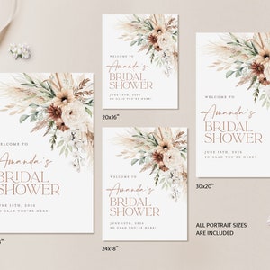 Op de afbeelding: Een set welkomstborden voor een bruidsdouche, met bloemstukken in neutrale tinten. De borden tonen de tekst "Welcome to Amanda's Bridal Shower, June 19th, 2026, So Glad You're Here!" in een stijlvol lettertype. Maten: 91x61cm, 51x41cm, 76x51cm, en 61x46cm.