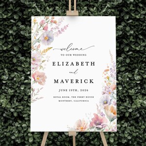 May include: A wedding welcome sign with a floral design in shades of pink, purple, and yellow. The sign reads "Welcome to our wedding, Elizabeth and Maverick, June 19th, 2026, Royal Room, The Perry House, Monterey, California."