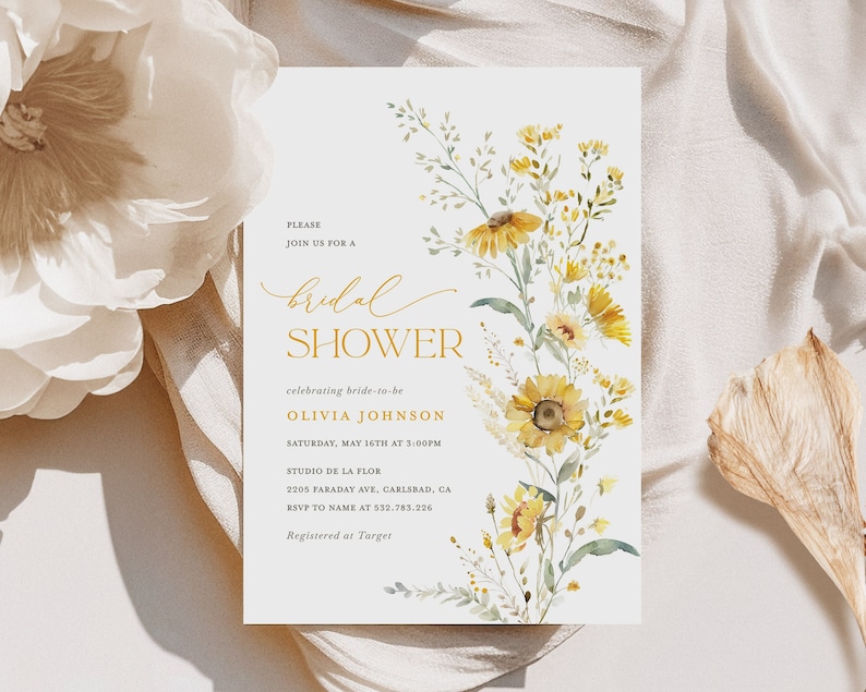 May include: A white bridal shower invitation with a watercolor illustration of yellow flowers and green leaves. The text reads "Please join us for a bridal shower celebrating bride-to-be Olivia Johnson Saturday, May 16th at 3:00PM Studio de la Flor 2205 Faraday Ave, Carlsbad, CA RSVP to name at 532.783.226 Registered at Target"