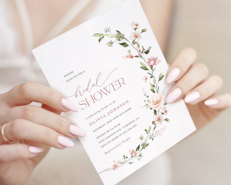 May include: A white bridal shower invitation with pink floral illustrations and the text "PLEASE JOIN US FOR A bridal SHOWER celebrating bride-to-be OLIVIA JOHNSON SATURDAY, MAY 16TH AT 3:00PM STUDIO DE LA FLOR 2205 FARADAY AVE, CARLSBAD, CA RSVP TO NAME AT 532.783.226 Registered at Target"