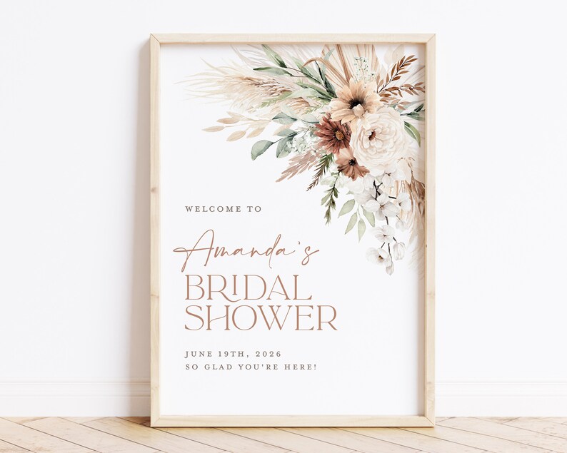 Op de afbeelding: Een ingelijste bruidsdouche-bord met een bloemstuk rechtsboven. Het bord leest "Welkom bij Amanda's Bridal Shower" met de datum 19 juni 2026 en de zin "Zo blij dat je er bent!"