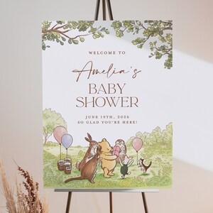 Puede incluir: Un cartel de bienvenida para un baby shower con tem&aacute;tica de Winnie the Pooh con un borde de hojas verdes y marrones. El cartel dice "Bienvenido al Baby Shower de Amelia 19 de junio de 2026 &iexcl;Encantados de que est&eacute;s aqu&iacute;!" y presenta a Winnie the Pooh, Piglet, Tigger, Eeyore y Owl.