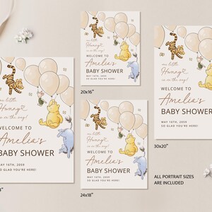 Pode incluir: Placa de ch&aacute; de beb&ecirc; com personagens de Winnie the Pooh, bal&otilde;es e o texto "Bem-vinda ao ch&aacute; de beb&ecirc; de Amelia". O design inclui ilustra&ccedil;&otilde;es de Tigr&atilde;o, Pooh e Leit&atilde;o. Dispon&iacute;vel em v&aacute;rios tamanhos.