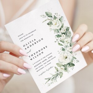 May include: White wedding invitation with green foliage and white flowers. The invitation reads "Please join us to celebrate the wedding of Olivia Anderson and Theodore Wilson 6 o'clock in the evening August 16th, 2026 ABC Room, The Ferry House Monterey, CA 93940 reception to follow"