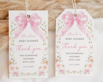 Könnte beinhalten: Zwei Babyparty-Geschenkanhänger mit rosa Schleife und floralem Design. Die Anhänger tragen die Aufschrift "Amelias Babyparty" und "Danke" mit dem Datum 05.19.2059. Die Anhänger sind rechteckig und haben eine Schnur.