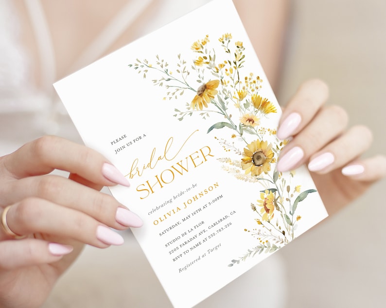 May include: A white bridal shower invitation with a gold floral design. The invitation includes the text "PLEASE JOIN US FOR A bridal SHOWER celebrating bride-to-be OLIVIA JOHNSON SATURDAY, MAY 16TH AT 3:00PM STUDIO DE LA FLOR 2005 FARADAY AVE, CARLSBAD, CA RSVP TO NAME AT 532.783.226 Registered at Target"