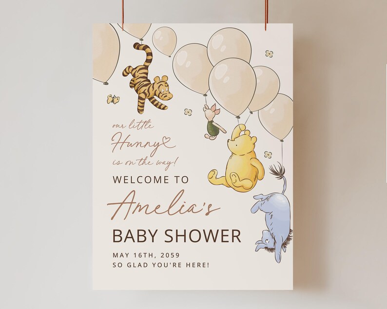Pode incluir: Um letreiro de ch&aacute; de beb&eacute; com ilustra&ccedil;&otilde;es de personagens de Winnie the Pooh, bal&otilde;es e borboletas. O letreiro diz "our little Hunny is on the way! Welcome to Amelia's Baby Shower" com a data de 16 de maio de 2059.