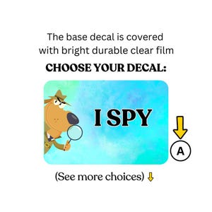 May include: A rectangular decal featuring the words "I SPY" on a blue and green background. A cartoon dog detective with a magnifying glass is on the left. The text "CHOOSE YOUR DECAL:" is above the image, and "(See more choices)" is below.