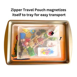 May include: A clear mesh zipper pouch filled with colourful toys and accessories sits inside a gold-coloured metal tray. The text "Zipper Travel Pouch magnetizes itself to tray for easy transport" is at the top.