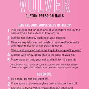 Op de afbeelding: Roze achtergrond met witte tekst die "VOLVER CUSTOM PRESS-ON NAILS" luidt. Onder de tekst staan instructies voor het aanbrengen en verwijderen van press-on nagels.
