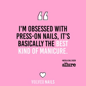 Op de afbeelding: Een roze achtergrond met een witte quote-bubble met de tekst "I'M OBSESSED WITH PRESS-ON NAILS, IT'S BASICALLY THE BEST KIND OF MANICURE." De quote wordt toegeschreven aan "NICOLA DALL'ASEN" en het woord "allure" is in wit onder de quote gedrukt. Een wit hart bevindt zich onder de tekst "VOLVER NAILS".