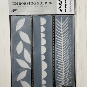 May include: A set of three clear plastic embossing folders with different designs. The designs include leaves, scallops, and a fern. The folders are labeled "Darice" and "3pc".