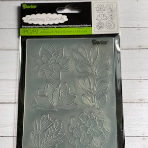 May include: A clear plastic embossing folder by Darice, featuring succulent and leaf designs. The package includes the text "Embossing Essentials" and measurements of 4.25 x 5.75 inches.