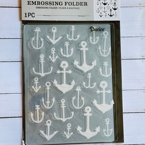May include: A clear plastic embossing folder with a white anchor design. The folder is labeled "Embossing Folder" and "Darice".