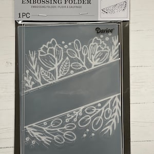 May include: A clear plastic embossing folder with a white floral design. The folder is packaged in a clear plastic sleeve with a white label that reads "Embossing Folder" and "Darice".