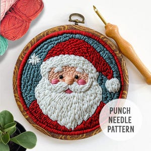May include: A punch needle pattern featuring a Santa Claus design. The pattern is completed and framed in a wooden hoop. The finished piece is red, white, and blue.